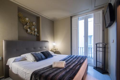 a bedroom with a large bed and a large window at Cosy Rooms Tapinería in Valencia