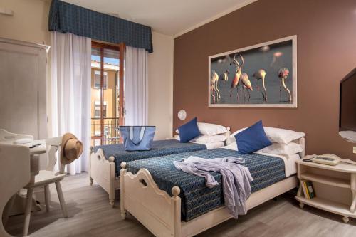 a bedroom with a bed with a painting of flamingos at Hotel Corallo in Albinia
