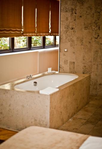 a bath tub in a bathroom with a window at CORTIINA Hotel in Munich