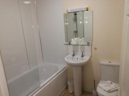 a bathroom with a sink and a tub and a toilet at Crown Hotel Brackley in Brackley