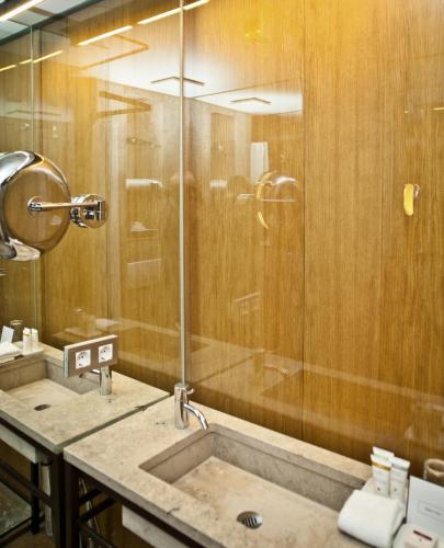 a bathroom with a shower and a sink at CORTIINA Hotel in Munich