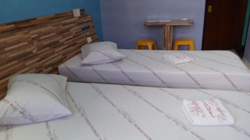 two twin beds in a room with two chairs at Hotel Carpe Diem in Sao Paulo