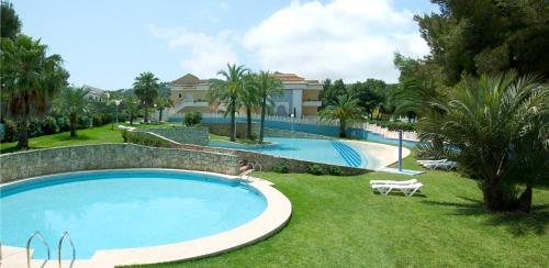 una gran piscina en un patio junto a una casa en Aparthotel Bahia Pinosol en Jávea