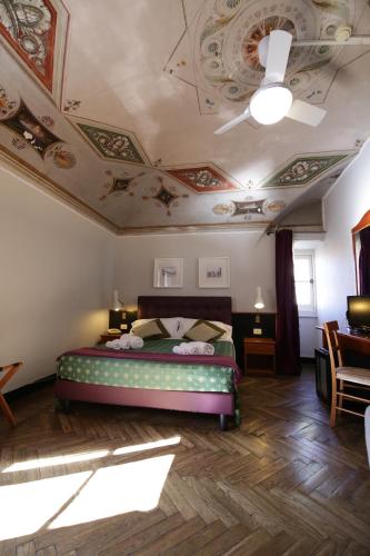 a bedroom with a bed and a ceiling with paintings at Hotel Villa Bonera in Genoa