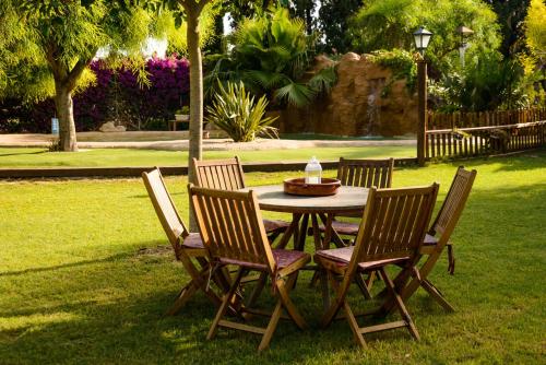 a wooden table with four chairs in the grass at Lo Racó de Peret in Camarles