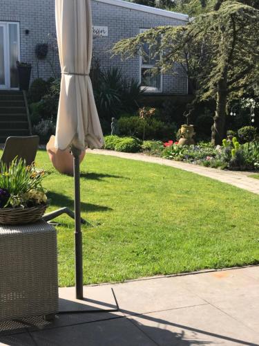 a white umbrella sitting next to a lawn at Villa 't Haasduin in Wijk aan Zee