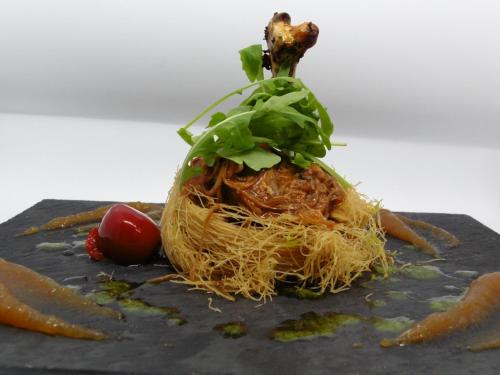 um ninho de macarrão e vegetais sobre uma mesa em Logis Hotel Restaurante La Casa de Juansabeli em Arenas de Cabrales