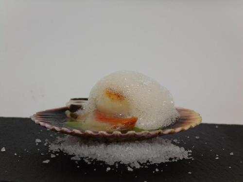 a piece of food on a plate with sugar on it at Logis Hotel Restaurante La Casa de Juansabeli in Arenas de Cabrales