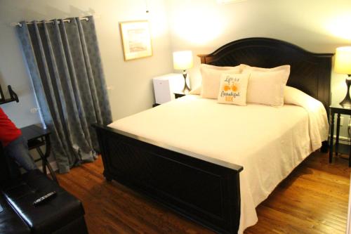 a bedroom with a large bed with white sheets and pillows at Tandem Bike Inn in Belmar