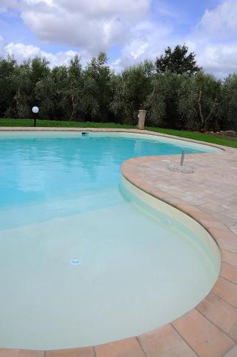 a large swimming pool with blue water at Cerchio Verde in Pitigliano