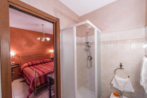 uma casa de banho com chuveiro e uma cama num quarto em Locanda del Borgo em Todi