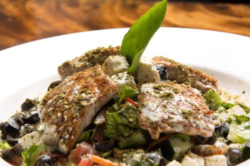 a plate of food with meat and vegetables on a table at Beach Break Hotel & Surf Camp de Playa Venao in Playa Venao