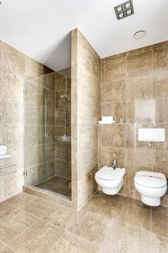 a bathroom with a shower and a toilet and a sink at Penthouse direkt am Meer in Los Realejos