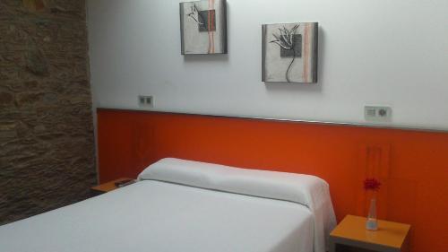 a room with a bed and two pictures on the wall at Albergue Turistico Salceda in Salceda