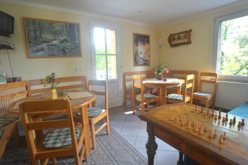 a dining room with tables and chairs and a chessboard at Bušeranda - depandance Hotelu U Zeleného stromu in Děčín