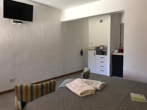 a bedroom with a bed with a tv on the wall at Complejo El Faro in Santa Rosa de Calamuchita