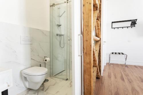 uma casa de banho com um WC e uma cabina de duche em vidro. em Lisbon Check-In Guesthouse em Lisboa