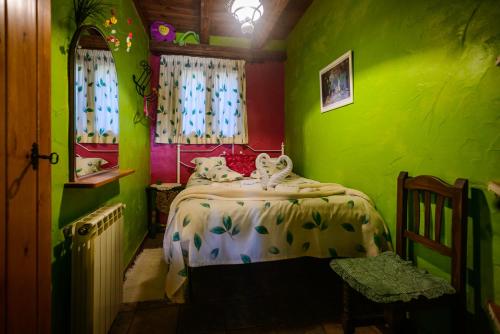 a green room with a bed and a window at Lo Racó de Peret in Camarles
