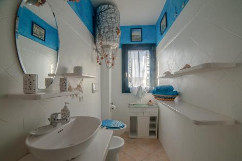 a bathroom with a sink and a toilet and a mirror at Casa Vacanza Sardegna in Valledoria