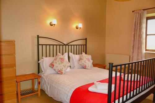 1 dormitorio con 1 cama con sábanas y almohadas blancas en Upper Onibury Cottages, en Onibury