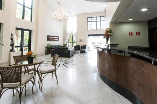 a lobby with a bar with chairs and a table at Tsue The Palace Flats in Sao Paulo
