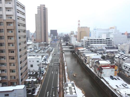 a view of a city with a river and buildings at APA Hotel Akita Senshu Koen in Akita