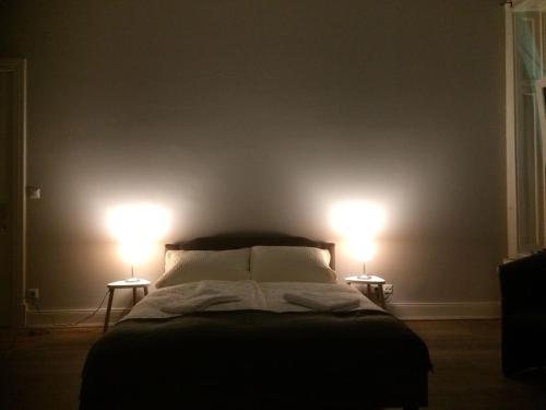 a bedroom with a bed with two lights on the wall at St. Pauli Lodge Townhouse in Hamburg