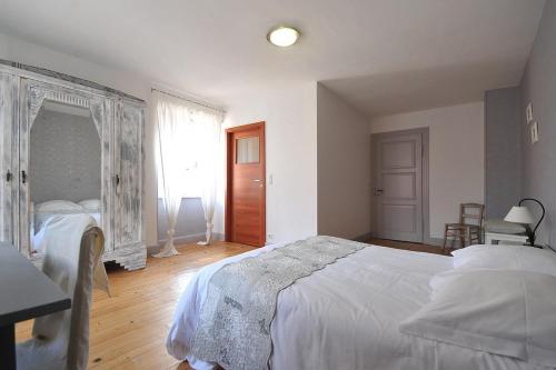 a bedroom with a large white bed and a window at Maison D'hôtes Du Landersbach in Sondernach