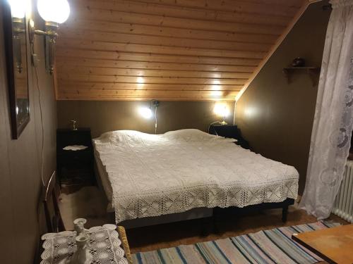a bedroom with a bed with a wooden ceiling at Christinagården Guesthouse in Ramsele