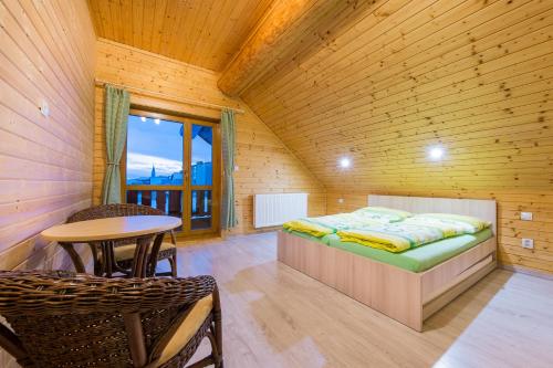 een slaapkamer met een bed en een tafel in een kamer bij Zrub pod Kriváňom in Liptovská Kokava