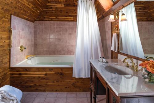a bathroom with a tub and a sink at Manor House Inn in Norfolk