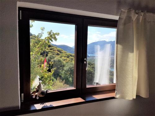 une fenêtre avec vue sur une cascade dans l'établissement Collinetta di Montagnola, à Montagnola