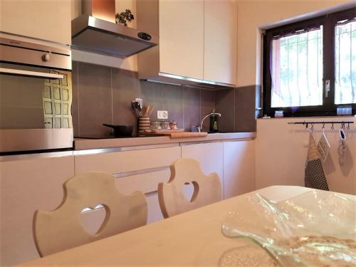 cocina con armarios blancos y mesa en Collinetta di Montagnola, en Montagnola