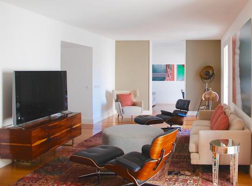- un salon avec un canapé, une télévision et des chaises dans l'établissement Santa Catarina Luxury Apartment, à Lisbonne