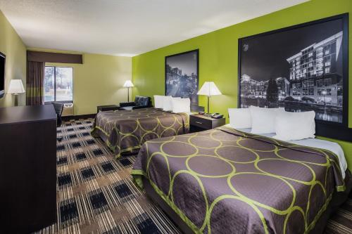 a hotel room with two beds and green walls at Super 8 by Wyndham Greer/Spartanburg Area in Greer