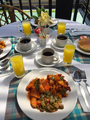 a table with a plate of food and orange juice at Grand Gardenia in Atlixco