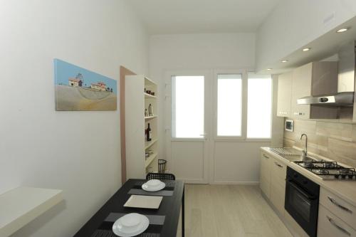 cocina con paredes blancas y encimera negra en Le Gemme 1, en Empoli