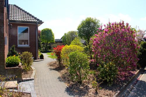 a garden with colorful bushes and a house at Ferienwohnungen Schoofs in Kalkar