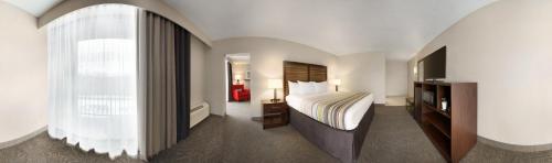 um quarto de hotel com uma cama e uma janela em Country Inn & Suites by Radisson, Erlanger, KY em Erlanger