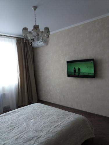 1 dormitorio con 1 cama y TV en la pared en Альтаир2 en Odesa