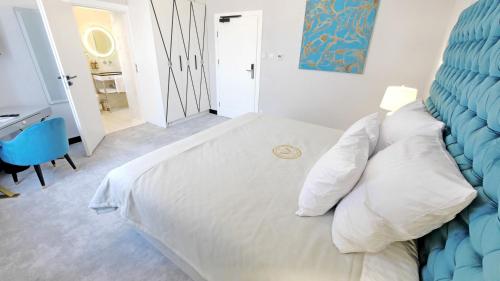SZEWSKA 22 BOUTIQUE في كراكوف: غرفة نوم مع سرير أبيض مع اللوح الأمامي الأزرق