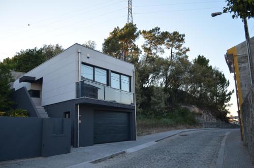 a house with a garage on the side of a road at Quinta das Cutamas in Pedrouços