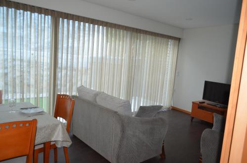 a living room with a couch and a table and a television at Quinta das Cutamas in Pedrouços