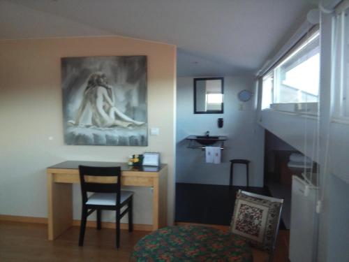 a room with a desk and a chair and a painting at Penthouse - Low Cost in Vouzela