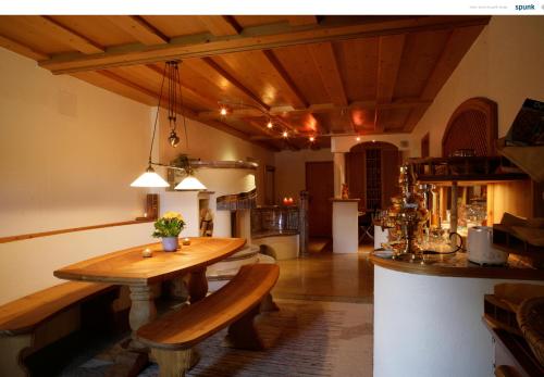 a dining room with a wooden table and a kitchen at Landhaus Kössel in Füssen