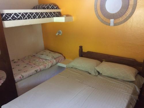 two bunk beds in a room with a window at Casa Colonial Térrea no Saco da Capela em Ilhabela in Ilhabela