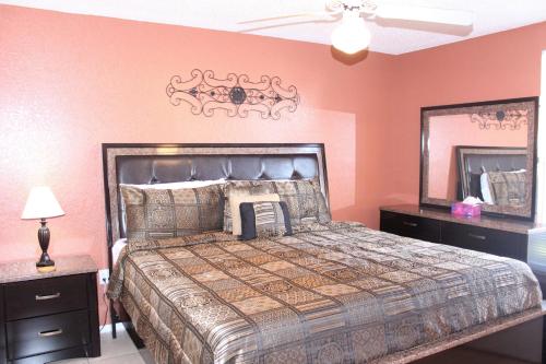 1 dormitorio con 1 cama grande y espejo en Tamarind Villa MK015, en Kissimmee