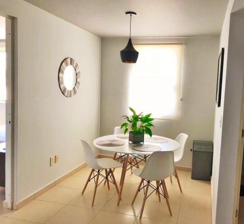a dining room with a white table and chairs at Becerra Apartments in Mexico City