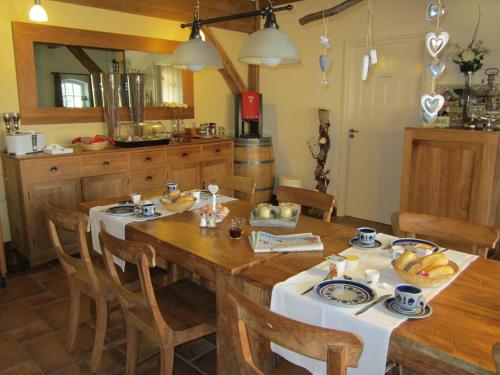 a kitchen with a large wooden table with chairs at De Martiene Plats B&B & Appartement in Merselo