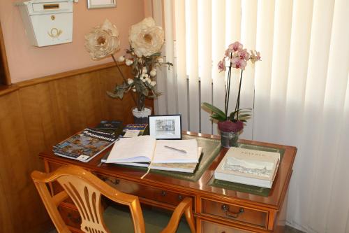 a wooden desk with a table with flowers on it at Hotel Berlin in Leipzig